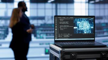 Laptop in data center facility with artificial intelligence computing simulating human brain, handheld camera shot. Close up of device displaying AI machine learning algorithms in server hub, camera A photo