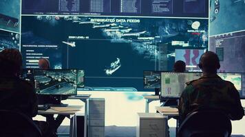 Army personnel applying national safety protocols by verifying all ships anchoring in the coastal ports, using radar surveillance on big screen in military command post. Federal operations. Camera B. photo