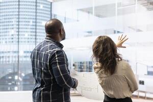 Broker and client sharing a development vision for the new office space in a high class urban building, realtor working with entrepreneur to negotiate a property leasing contract. photo