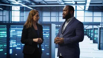 African american expert and coworker looking at holograms in data center, working together. Team members interacting with augmented reality AI visualization in server hub, camera A photo
