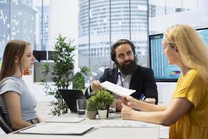 Financial advisor establishing emergency fund for woman and gen Z girl before investing. Agent discussing in office meeting with clients, providing financial security in case of unexpected emergencies photo