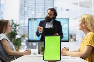 Focus on isolated screen tablet used by financial advisor in blurry background to calculate clients net worth. Close up shot of chroma key device used by agent to help family pick investments photo