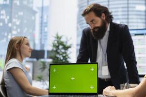 Financial adviser presents market analytics on isolated screen laptop to clients, teaching them how to build portfolio. Broker showing stock exchange charts on chroma key notebook to family photo