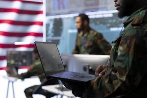 Military specialists in a high tech US command center manages surveillance systems, cybersecurity and data protection. Soldiers ensuring national security through advanced technology. photo