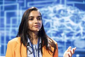 Speaker using headset mic to talk at event bringing together industry specialists to share insights on latest advancements in AI. Close up shot of CEO speaking at expo in front of entrepreneurs photo