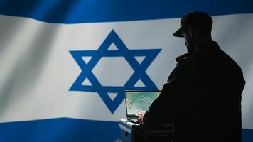 Iranian conscript in control room uses military tech to identify threats from enemies. Iran IDF army operator uses software on laptop to communicate information to generals on war front line, camera B photo