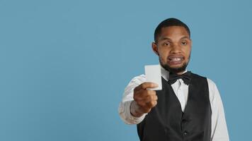 Bellhop personnel offering access card to the room for guests, presenting the key after check in procedure. Hotel porter employee providing lodging and five star amenities at the resort. Camera A. photo