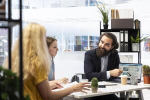 Financial advisor using laptop in office to present clients volatile stock exchange prices going up and down. Family getting consulted on forex trading platforms by brokerage firm expert photo
