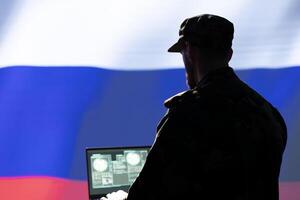 Russian KGB engineer making bot accounts spreading malware online to attack Western powers. Soviet FSB IT expert working for Kremlin regime coding troll farm promoting socialism doctrine photo