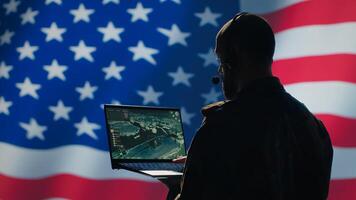 US Air Force dispatcher looking at surveillance transmission on device, relaying data to ground soldiers from control room using headset, isolated over United States flag background, camera A photo