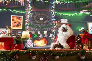 Father Christmas reading letters and lists in his festive workshop, white bearded man opening mailbox. Surrounded by holiday lights and decorations, Santa prepares gifts for joyful traditions. photo