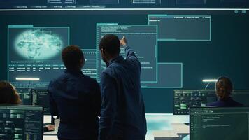 Cyber security team conducting cyber surveillance in a governmental control room. Experts group hacking activities, malware protection and data breach prevention in high tech agency. Camera B. photo