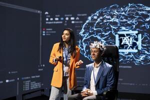Specialists speaking at neuroscience tech expo, exploring latest AI technology and neural implants. Smiling researcher and guest presenting latest EEH headset and artificial intelligence innovations photo
