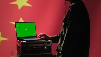 Chinese air defense using radar system on green screen laptop to detect intercontinental ballistic missiles. Republic of China army soldier scanning rockets with mockup notebook, camera A photo
