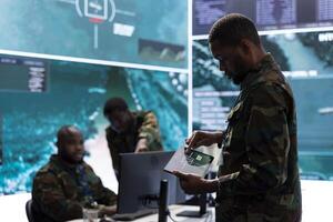 Group of soldiers in a secure office environment collaborates on intelligence analysis, and strategic planning. Showing crucial efforts for maintaining national security and operational efficiency. photo