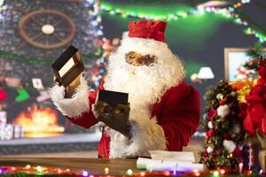 Saint Nicholas checking a gift box with a light shining bright from it, opening all the presents before leaving on the Christmas eve journey. Black Santa verifying the toys as a holiday preparation. photo
