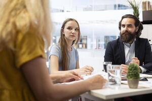 Financial advisors meeting with clients to counsel them on their finances and give them personalized financial plan. Agent guiding family in making profitable and secure decisions photo