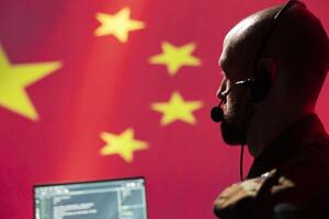 Chinese engineer making bot accounts spreading viruses on internet to attack Western powers. Close up of IT expert working for China PsyOp military intelligence coding troll farm promoting communism photo
