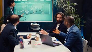 Office administrator presenting data reports and funding on interactive board, deliberating on income analysis with her associates. Accomplishing enterprise financial objectives. Camera B. photo
