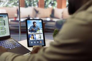 Businessman presents annual sales reports to the shareholders on videocall, working from home to increase funding. Entrepreneur making a development presentation for the investors. photo