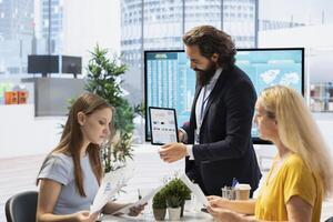 Financial advisor guiding mother and daughter in trading shares and making informed investment decisions. Broker offering customers guidance on buying, selling, or holding stocks to optimize returns photo