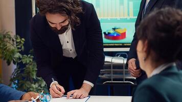 Business administrators shaking hands and signing a new contract, starting fruitful collaboration between their enterprises. Leaders agreeing to terms, organizational growth and success. Camera A. photo