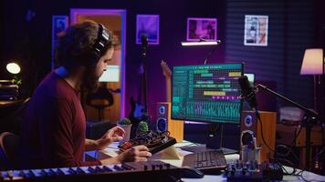 Audio engineer creating sound effects for a new soundtrack, recording tunes on electronic piano and adding creativity to audio project. Songwriter producer editing and mixing recordings. Camera B. photo