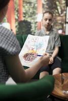 Psychologist reviewing scary sinister sketches by a troubled adolescent, displaying dangerous, unsettling emotions. The drawings suggest depression, aggression and social disorders. Close up. photo