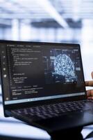 Computer scientist using laptop in data center, updating AI systems. Close up shot of device used by server room worker upgrading artificial intelligence simulation model photo