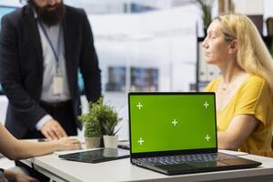 Financial adviser doing presentation on isolated screen laptop to help clients build saving habits, close up. Agent using chroma key notebook to show customers investing tips photo