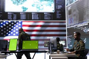 US army working in a top secret control center with isolated mockup screen, ensuring national safety while studying surveillance footage from radar cctv. Command service. photo