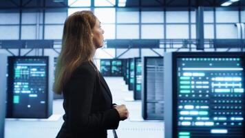 Engineer inspecting server room hardware, walking between supercomputers. IT professional supervising data center workplace, checking equipment, monitoring performance, camera A photo
