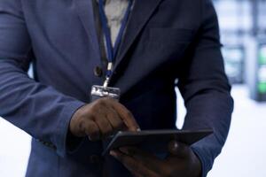 Data center admin ensuring safety and security of database using device. Close up of server hub expert preventing unauthorized access and suspicious activities posing risks for business photo