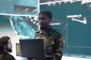 Professional intelligence officer managing cybersecurity measures to protect government data from enemy breaches, working from a control room power base. National safety military division. photo