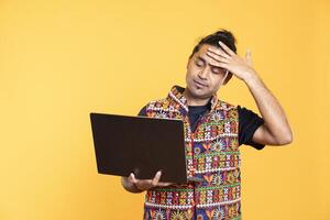 Upset person doing face palm gesturing after seeing error message on laptop screen while doing job tasks, studio background. Overworked employee feeling headache while working photo