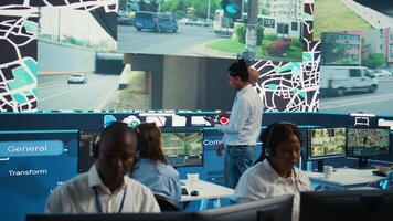 Diverse employees at call center transmitting gps coordinates of routes without traffic to help with express order delivery. Operators following surveillance footage on radar system and map. Camera B. photo