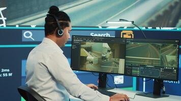 Indian call center operator giving updates about order to clients, ensuring fast delivery from observation room. Employee searching for routes without traffic on CCTV real time footage. Camera A. photo