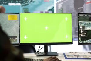 Recruit operates on reconnaissance CCTV footage with green screen, using military radar imagery in military control room. Monitoring real time data in a defense base of operations, security mission. photo