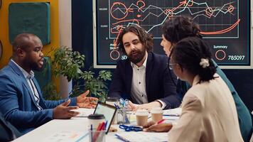Startup team evaluating infographics data in an executive meeting, corporate restructuring or organizational changes. Adapting the organization to evolving market conditions. Camera A. photo