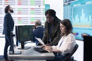 Coworkers team analyzing infographics to provide solutions on an issue affecting the project, looking to finish tasks before deadline. Business employees working together to ensure progress. photo