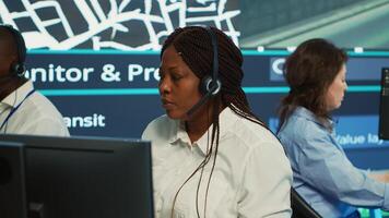 Diverse employees at call center transmitting gps coordinates of routes without traffic to help with express order delivery. Operators following surveillance footage on radar system and map. Camera A. photo