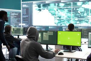 Governmental hackers using green screen in performing cyber security monitoring and threat detection. Examining network security and protection against cyber attacks, national intelligence. photo