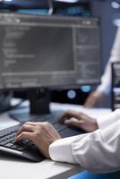 Admin in data center checking equipment performance on computer after upgrading infrastructure. Close up shot of IT employee doing maintenance on storage arrays in servers room photo