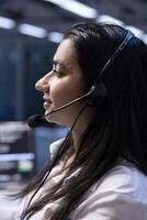 Technician in data center providing support for partnering companies, troubleshooting errors. Woman in modern server hub facility carrying out operational interventions requested by clients photo
