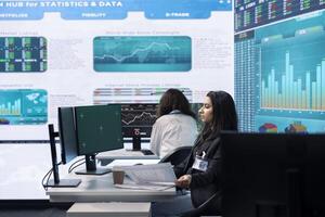 Business analyst reviewing performance indicators in office space, looking at a pc display with isolated copy space. Woman working on enterprise global expansion plans. Teamwork. photo