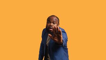 Stern african american man doing stop hand gesture sign. Annoyed BIPOC person doing firm halt sign gesturing, wishing to end concept, isolated over studio background, camera B photo