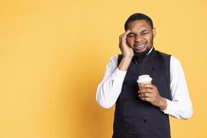 Restaurant employee dealing with a painful headache while he serves clients, carrying a cruet set for excellent customer satisfaction. Unwell waiter working in pain with migraine. photo