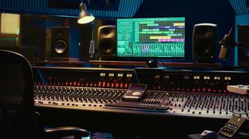 Empty control room professional studio used in music recording industry, mixing console and post production equipment. Soundproof space with daw software, faders and audio editing tools. photo