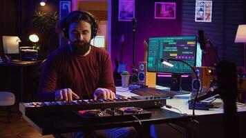 Artist playing piano keyboard and recording sounds for mix and master session, using daw software interface to produce new songs. Music producer composing tunes with midi controller. Camera B. photo