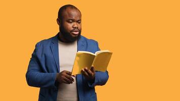 Man reading book aloud, narrating story for audience. Person enjoying literature novel, reciting from pages, entertaining spectators, isolated over studio background, camera A photo